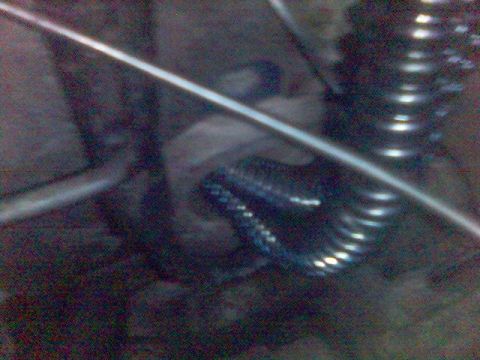 1994 Ford Probe - Undercarriage component detail: suspension spring and metal rod.