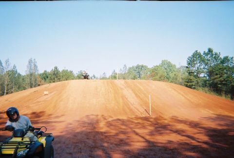 2003 Ford F-350 - ATVs on a dirt track with a rider in the foreground and another on the hill.