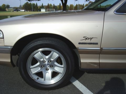 1993 Ford Crown Victoria - Close-up of the fender and wheel of a 1993 Ford Crown Victoria Sport, showing the 'Sport' and 'Crown Victoria' badging.