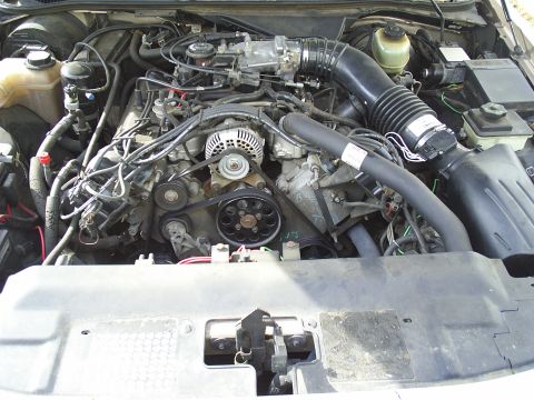 1993 Ford Crown Victoria - The engine compartment of a car is shown, with various mechanical components and wiring.