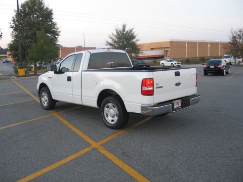 2004 Ford F-150 - A white Ford F-150 pickup truck is parked in a lot with yellow lines on the asphalt.