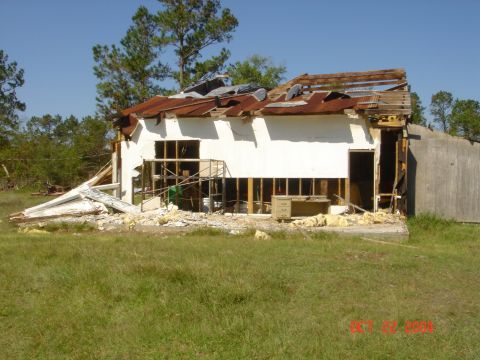 2002 Jeep Wrangler - A building severely damaged by Hurricane Rita, showing structural collapse and scattered debris.