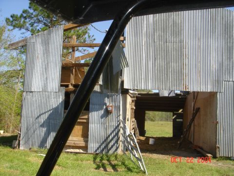2002 Jeep Wrangler - Photo shows a damaged barn with corrugated metal siding and exposed wooden beams.