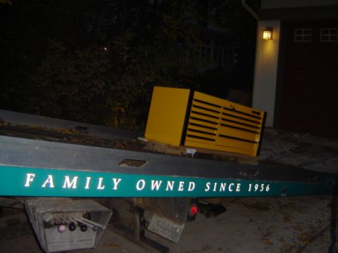 1992 Ford Bronco - A tow truck bed carries a yellow toolbox, with text indicating it has been family-owned since 1956.