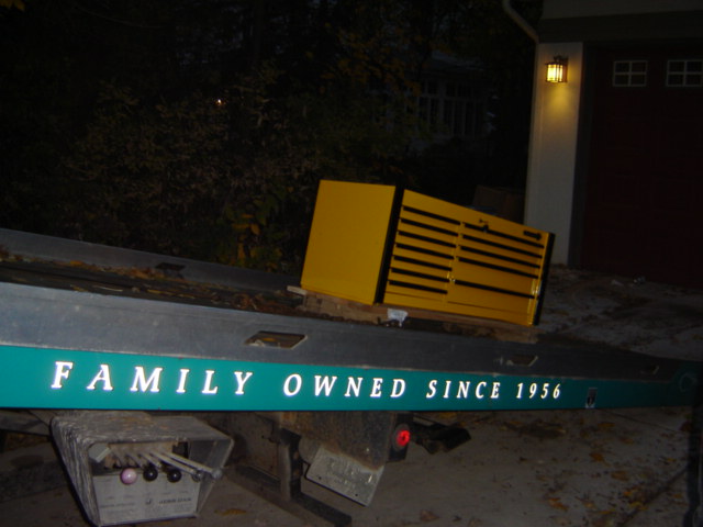 Tow truck bed with a yellow toolbox and the words "FAMILY OWNED SINCE 1956" visible