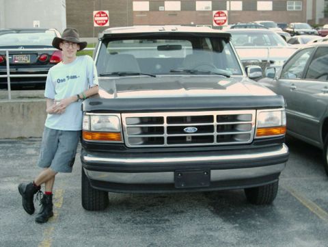 1992 Ford Bronco - A person stands next to a 1992 Ford Bronco in a parking lot.