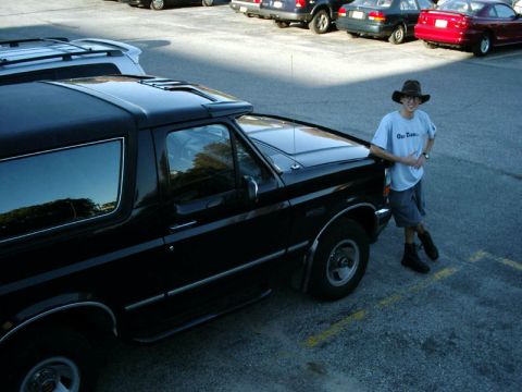 1992 Ford Bronco - A man poses with a black 1992 Ford Bronco in a parking lot.