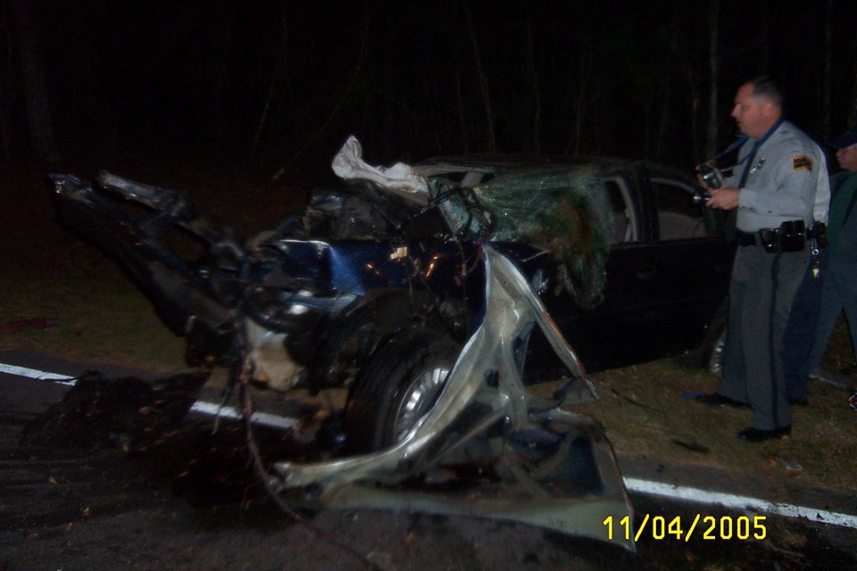 1998 Ford Crown Victoria, dark blue, heavily damaged front end, shattered windshield, side view