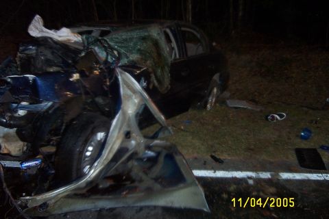 1998 Ford Crown Victoria - A severely damaged blue sedan sits on the side of the road after an accident, with the date 11/04/2005 visible.
