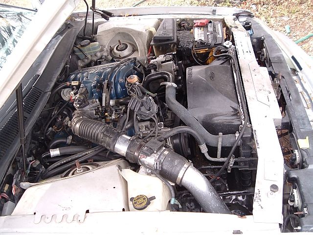 Engine bay with V6 engine, air intake, battery, and radiator
