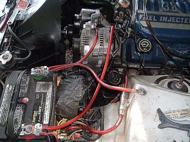 Ford 3.8 fuel injected V6 engine bay with red battery cables and alternator