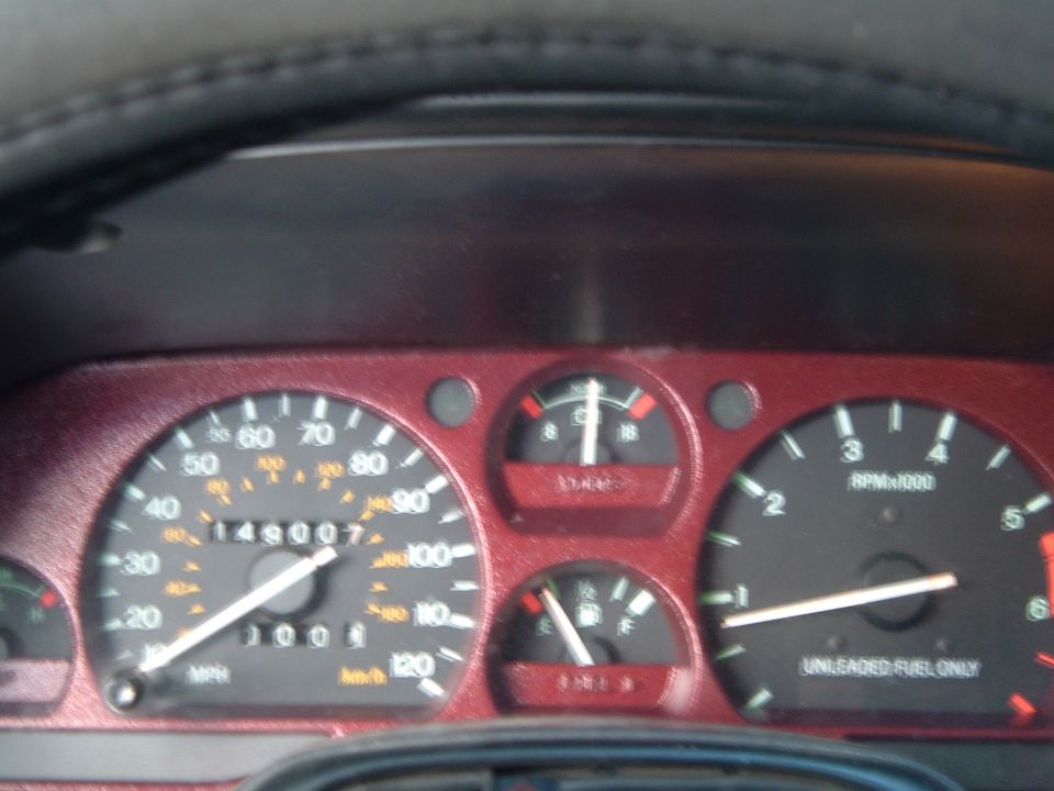 Close instrument cluster showing 149007 odometer, speedometer to 120, tach and Unleaded Fuel Only label