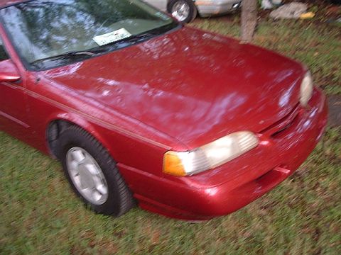 1994 Ford Thunderbird - Front quarter view of a red 1994 Ford Thunderbird parked outdoors.