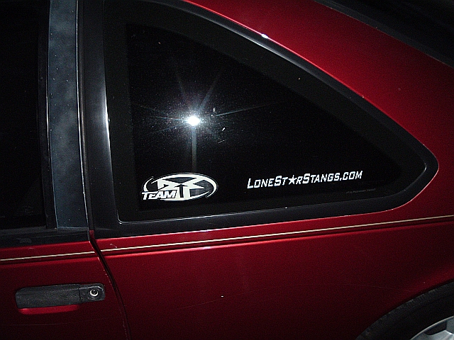 Red car's rear quarter window shows a 'TEAM' logo and 'LoneStarStangs.com' sticker