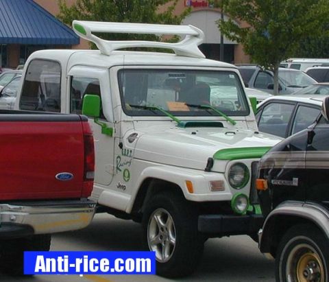 2000 Ford Taurus - A customized Jeep Wrangler is parked in a lot, a prominent rear spoiler and green trim details.