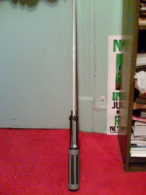 1997 Ford Probe - A lightsaber prop is shown standing upright on a red carpet in front of a light blue wall.
