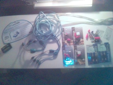 1994 Ford Probe - Various automotive electrical parts and accessories are laid out on a surface, including wiring and batteries.