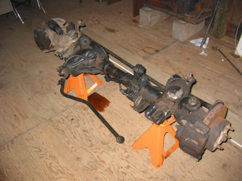 1991 Ford Explorer - A disassembled front axle assembly rests on jack stands, likely awaiting installation or repair.