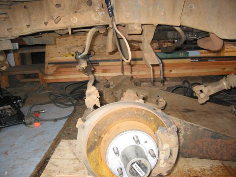 1991 Ford Explorer - Undercarriage view of a vehicle undergoing a solid axle swap, highlighting the suspension and brake assembly.