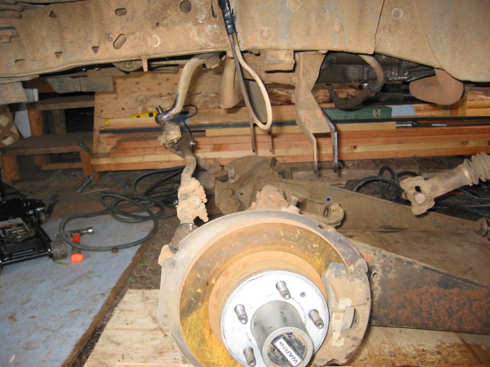 Undercarriage with solid axle swap, showing brake rotor and suspension components