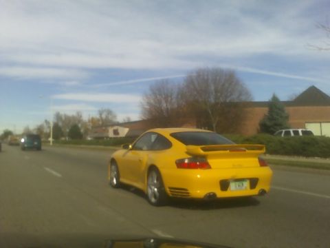 1996 Ford Probe - A yellow Porsche 911 with a rear spoiler is seen driving on a highway.