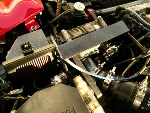 1993 Ford Probe - Close-up view of a modified engine bay, a supercharger and red air filter.