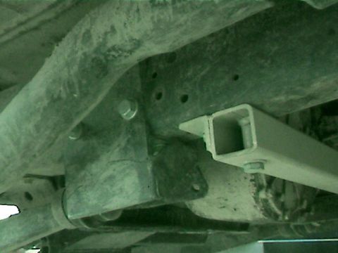 1977 Ford F-150 - Close-up of the undercarriage, showing the frame, suspension, and a trailer hitch receiver.