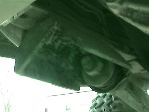 1977 Ford F-150 - Close-up view of a truck's undercarriage, showing mechanical components and a tire.