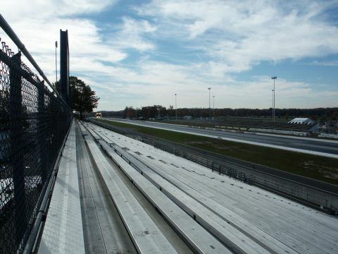 2001 Mercury Grand Marquis - A view of a drag strip and empty bleachers on a partly cloudy day.