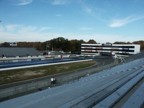 2001 Mercury Grand Marquis - A view of a drag strip and spectator seating, with a building prominently displaying the Dodge logo.