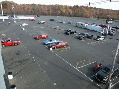 2001 Mercury Grand Marquis - A variety of vehicles are parked in a lot, with trees in the background and a Dodge sign visible.