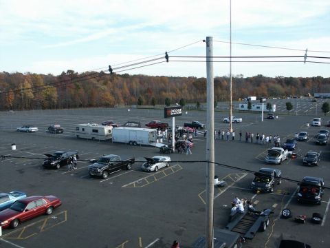 2001 Mercury Grand Marquis - A red 2001 Mercury Grand Marquis sedan is seen parked in a large lot with many other vehicles and trailers.