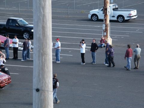 2001 Mercury Grand Marquis - A white pickup truck is parked in a lot with several people standing around.