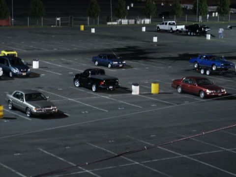 2001 Mercury Grand Marquis - Several vehicles are parked in a lot under artificial lighting at night.