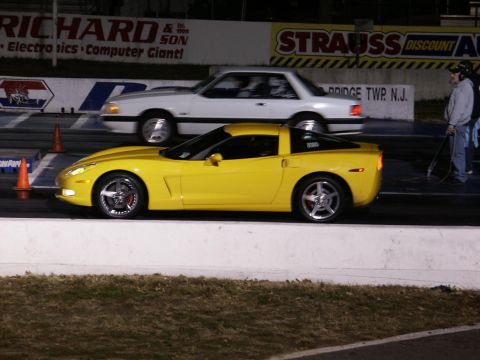 2001 Mercury Grand Marquis - A yellow Chevrolet Corvette C6 races a white Ford Mustang on a drag strip.
