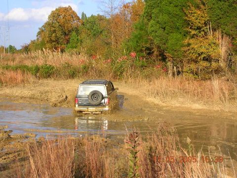 1989 Ford Bronco II - Ford Bronco II navigates a muddy off-road trail during autumn.