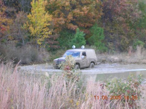 1989 Ford Bronco II - A Ford Bronco II navigates a muddy trail during autumn, with trees displaying fall colors.