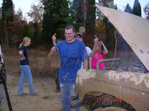 1989 Ford Bronco II - A group of people stand around a muddy 1989 Ford Bronco II with its hood open.