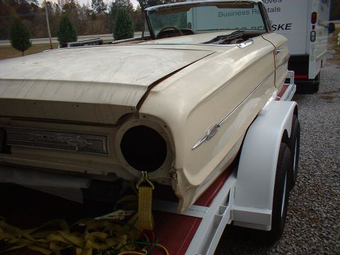 1964 Ford Galaxie - A cream 1964 Ford Galaxie convertible is seen on a trailer, showing its front quarter and side profile.