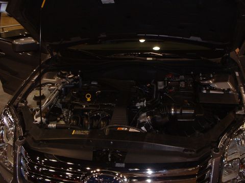 1999 Ford Crown Victoria - Car's engine bay is visible with the hood raised, revealing various mechanical parts.