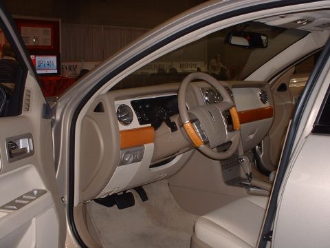 1999 Ford Crown Victoria - The interior of a car is shown, a dashboard with wood accents and a leather-wrapped steering wheel.