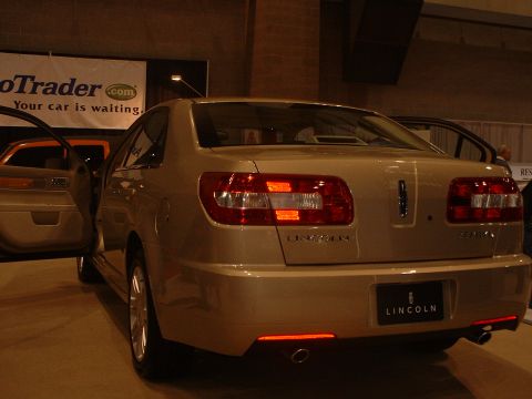 1999 Ford Crown Victoria - A gold Lincoln sedan is displayed with its doors open, showing the rear of the vehicle.