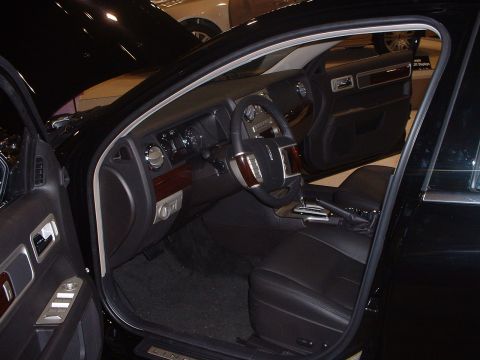 1999 Ford Crown Victoria - The interior of a Lincoln sedan is shown with the driver's side door open, revealing the dashboard and front seats.