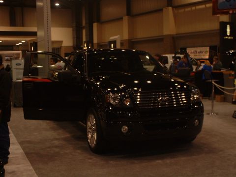 1999 Ford Crown Victoria - A black Ford F-150 pickup truck is displayed with its driver's door open at an auto show.