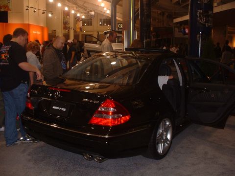 1999 Ford Crown Victoria - A black Mercedes-Benz AMG sedan is displayed with its doors open at an auto show.