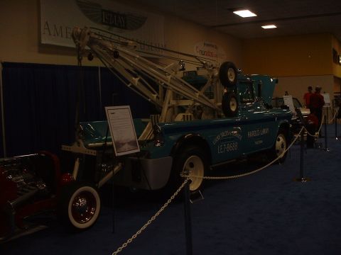 1999 Ford Crown Victoria - A vintage turquoise tow truck with a large white crane is displayed indoors.