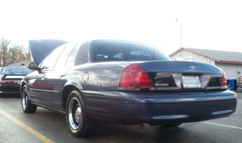 1998 Ford Crown Victoria - Rear view of a blue 1998 Ford Crown Victoria with its hood open, parked next to another vehicle.