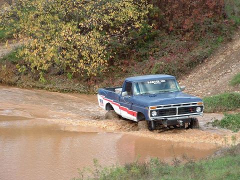 1977 Ford F-150 - This blue 1977 Ford F-150 navigates through a muddy water crossing.