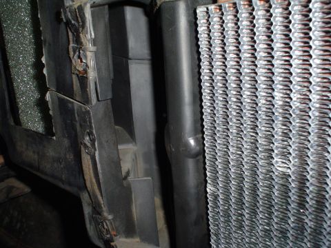 1984 Ford Bronco - The image shows a close-up view of a vehicle's radiator and surrounding plastic components, likely part of the cooling system.