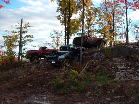1977 Ford F-150 - Multiple pickup trucks navigate a challenging rocky terrain during autumn.